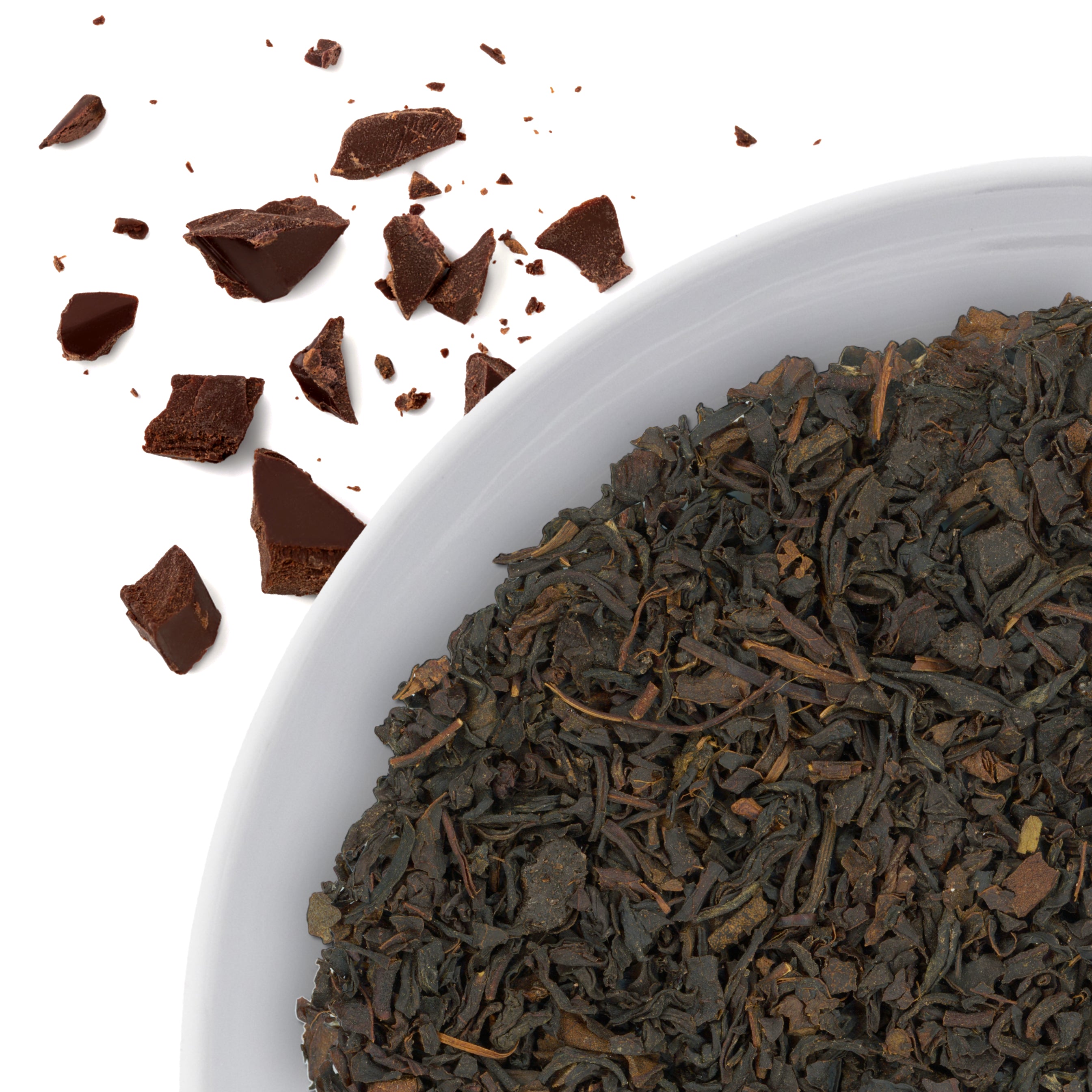 The corner of a bowl of Chocolate loose leaf black tea, with flavor notes displayed as crumbled chocolate pieces.