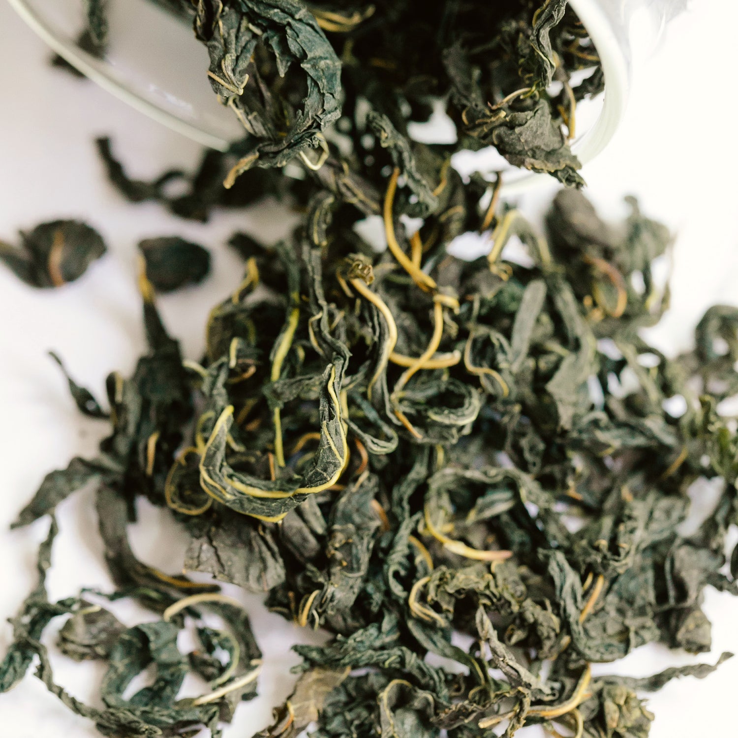 Loose leaf tea spilling out of a glass jar.