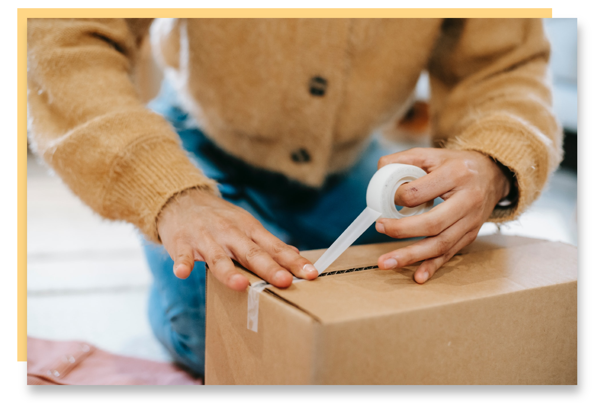 Close up of a person taping a brown cardboard box.